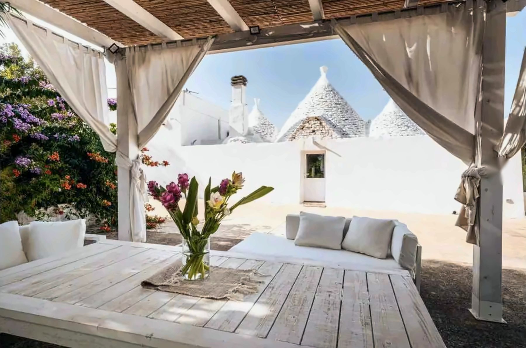 The pergola at Trullo Fedele Grande, framing the whitewashed trulli
